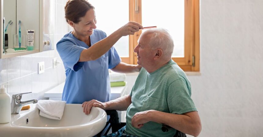 Personal female carer in UK combing geriatric male hair